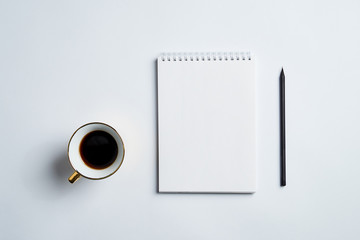 white office Desk top view with Notepad, pencil and coffee Cup, minimalistic design, top view,copy space,flat lay