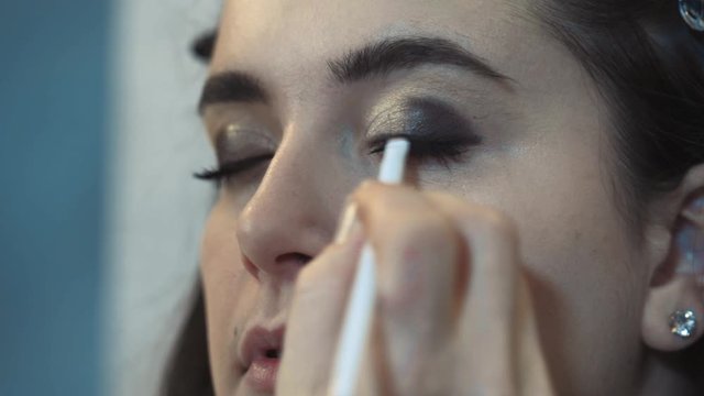 Close-up of a professional makeup artist applying tone and corrector for ever plus size model. Beauty concept, beauty industry.