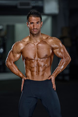 Fototapeta na wymiar Handsome Muscular Men Flexing Muscles at the Gym