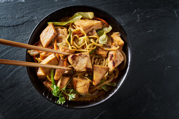 eating japanese chicken yakisoba with chopsticks in flat lay composition