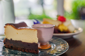 Close up view at chocolate cheese cake with syrup in cup on side dish .