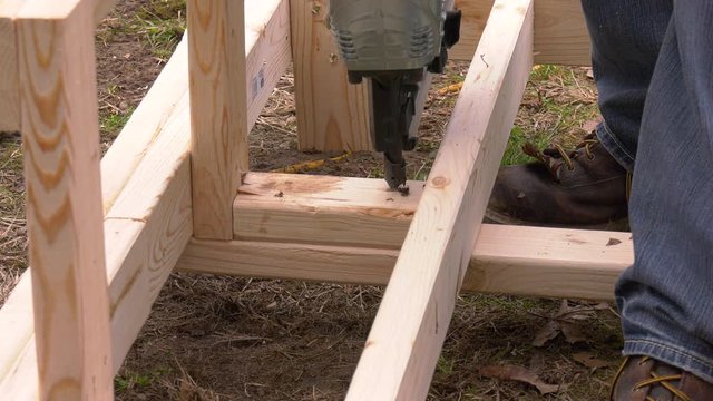 Pneumatic nail gun putting nails in boards with sound