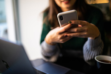 Young woman reading sms on the phone in cafe