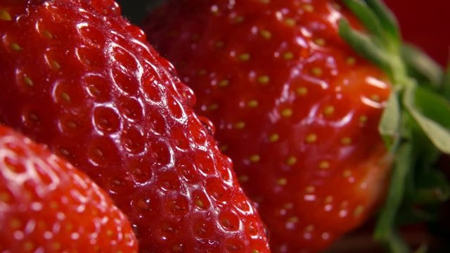 Close-up of ripe juicy strawberries with drop of water flowing over the surface