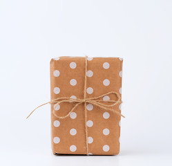 gift in box wrapped in brown kraft paper and tied with rope