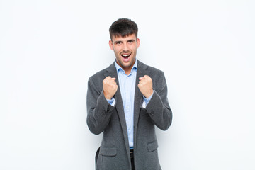 young handsome man shouting aggressively with annoyed, frustrated, angry look and tight fists,...