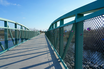 Walking bridge over river to other side, outdoor activities.