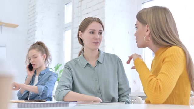 Beautiful Young Female Designers Sitting in Office and Talking 