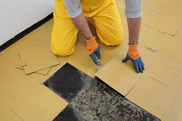 Old vinyl tiles removal from floor in a room or kitchen