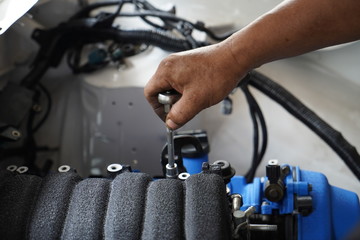 hand working on car's engine