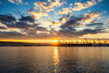 Fototapeta na wymiar Colorful sunset over sea port and industrial cranes, Varna, Bulgaria.