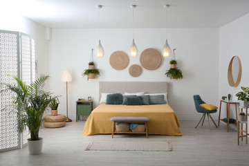 Stylish room interior with large comfortable bed