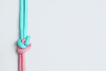 Colorful ropes tied together with knot isolated on white, top view. Unity concept