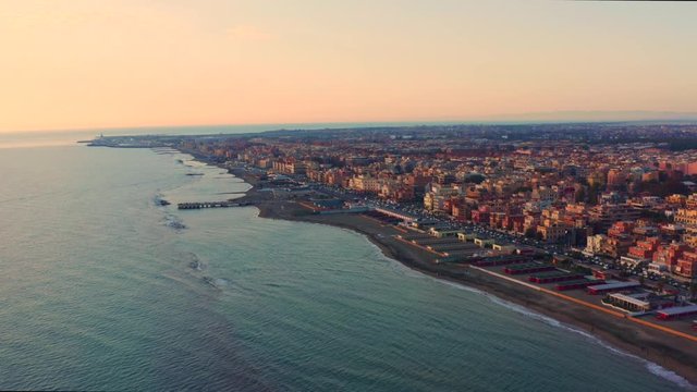 Aerial view of Italian Ostia Lido sandy beach, flying drone above sea, beautiful coastline from above at sunset, European resort