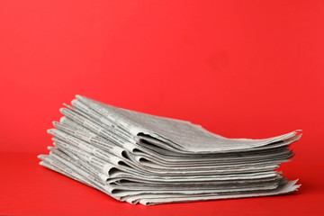 Stack of newspapers on red background. Journalist's work