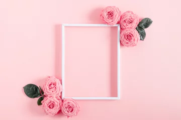 Zelfklevend Fotobehang Mooie bloemensamenstelling. Leeg frame voor tekst, roze roze bloemen op pastel roze achtergrond. Valentijnsdag, Pasen, Verjaardag, Gelukkige Vrouwendag, Moederdag. Platliggend, bovenaanzicht, kopieerruimte © prime1001