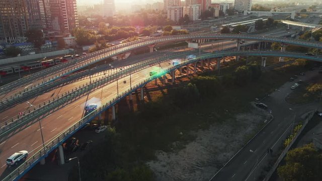 Amazing aerial presentation of the autonomous cars self-driving concept on the sunny evening in Moscow. Beautiful view from above to the road traffic on multi-level highway of big city.