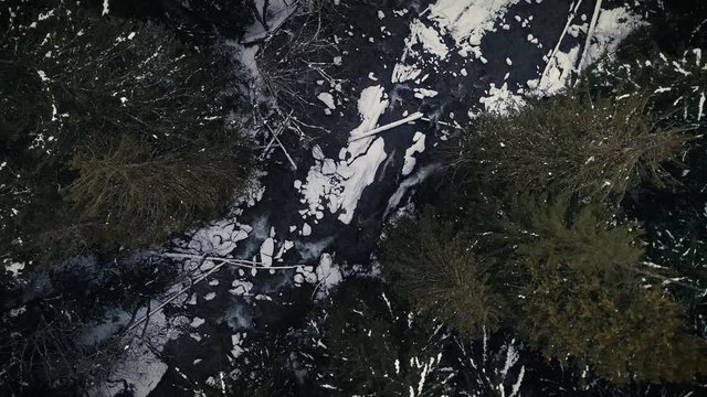 Melting Glacier Water in Snowy Forest River Shot by Drone Overhead