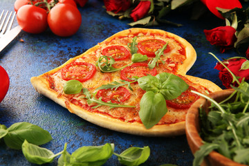 pizza Heart shaped margherita with tomatoes and mozzarella vegetarian. Food concept of romantic love pizza for Valentines Day.