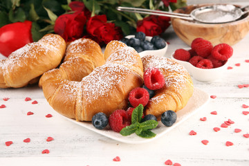 Delicious breakfast with fresh croissants and ripe berries and mint for valentines day