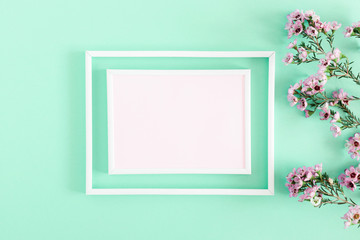 Beautiful flowers composition. Blank frame for text, pink flowers on pastel blue background. Valentines Day, Easter, Birthday, Happy Women's Day, Mother's day. Flat lay, top view, copy space