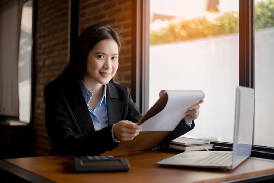 Successful business woman working at the office looking at camera