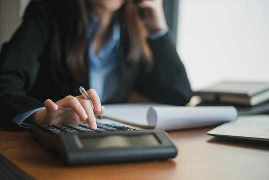 Close up of female accountant or banker making calculations. Savings, finances and economy concept