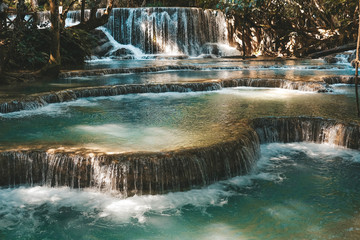 Majestic blue water flowing down multistep waterfall