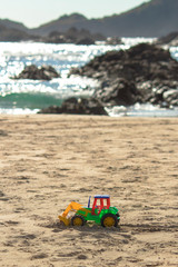 tractor de juguete en la playa 