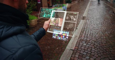 Close up of an young man is making a video call to his girlfriend with a futuristic latest innovative technology glass tablet with augmented reality holograms during walking in city center by day. - Powered by Adobe