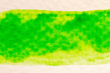 green stroke of the paint brush on white paper