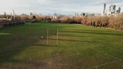Aerial drone view of amateur women playing american football or rugby in the park