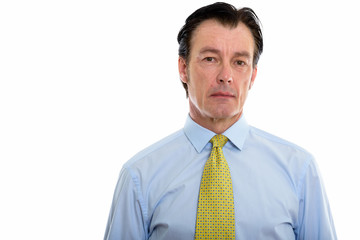 Studio shot of mature handsome businessman looking at camera