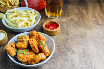 Table fof tasty snacks and beer prepared for watching sports on TV. Selective focus