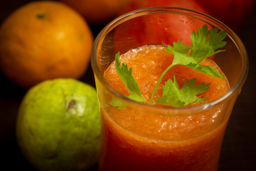 Healthy juice of papaya in a glass with fruits background. Use for healthy food concept.