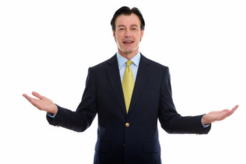 Studio shot of mature happy businessman smiling with open arms