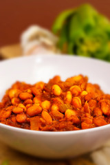 Bowl of Baked Beans with Garlic Bulbs in Background