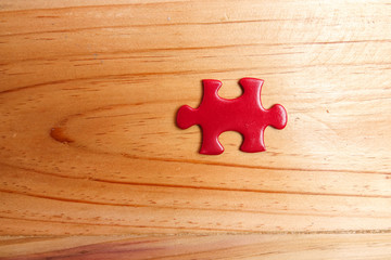 Missing red jigsaw puzzle on wooden table. Copy Space