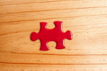 Missing red jigsaw puzzle on wooden table. Copy Space