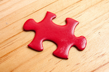 Missing red jigsaw puzzle on wooden table. Copy Space