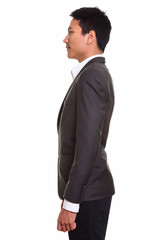 Obraz na płótnie Canvas Profile view of young Asian businessman in suit