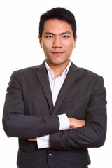 Close up of young Asian businessman with arms crossed