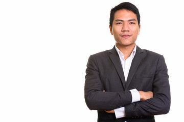 Studio shot of young Asian businessman with arms crossed
