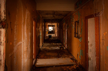 Fototapeta na wymiar Old ruined corridor of a children's camp. Ruined living space. The fallen walls.