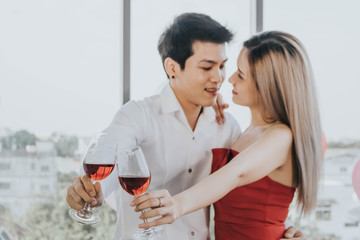 Young Asian couple celebrating new year together, drinking wine together.