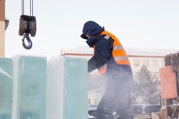 Worker cuts ice panel with gasoline saw