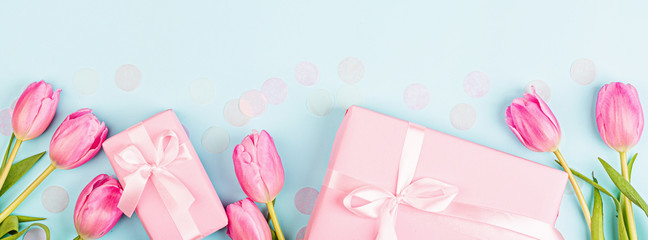 View from above tulips and gift box with copy space on blue. Background for womens day, 8 March...