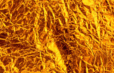 Gold crumpled foil paper texture background.