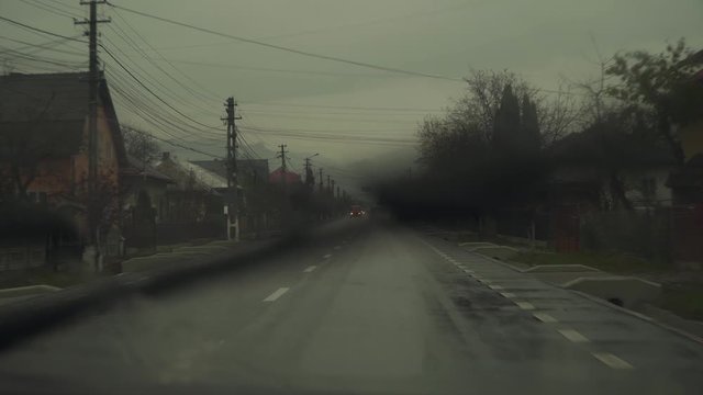 Driving A Car On A Long Narrow Road On A Rainy Day - Medium Shot