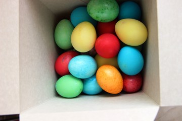 lots of multi-colored Easter eggs in a white square box. Easter preparations.